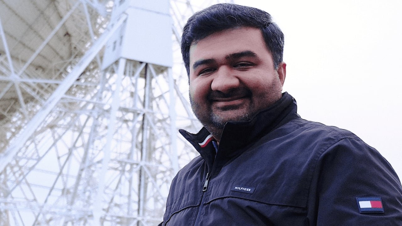 A man in a blue jacket smiling at the camera.