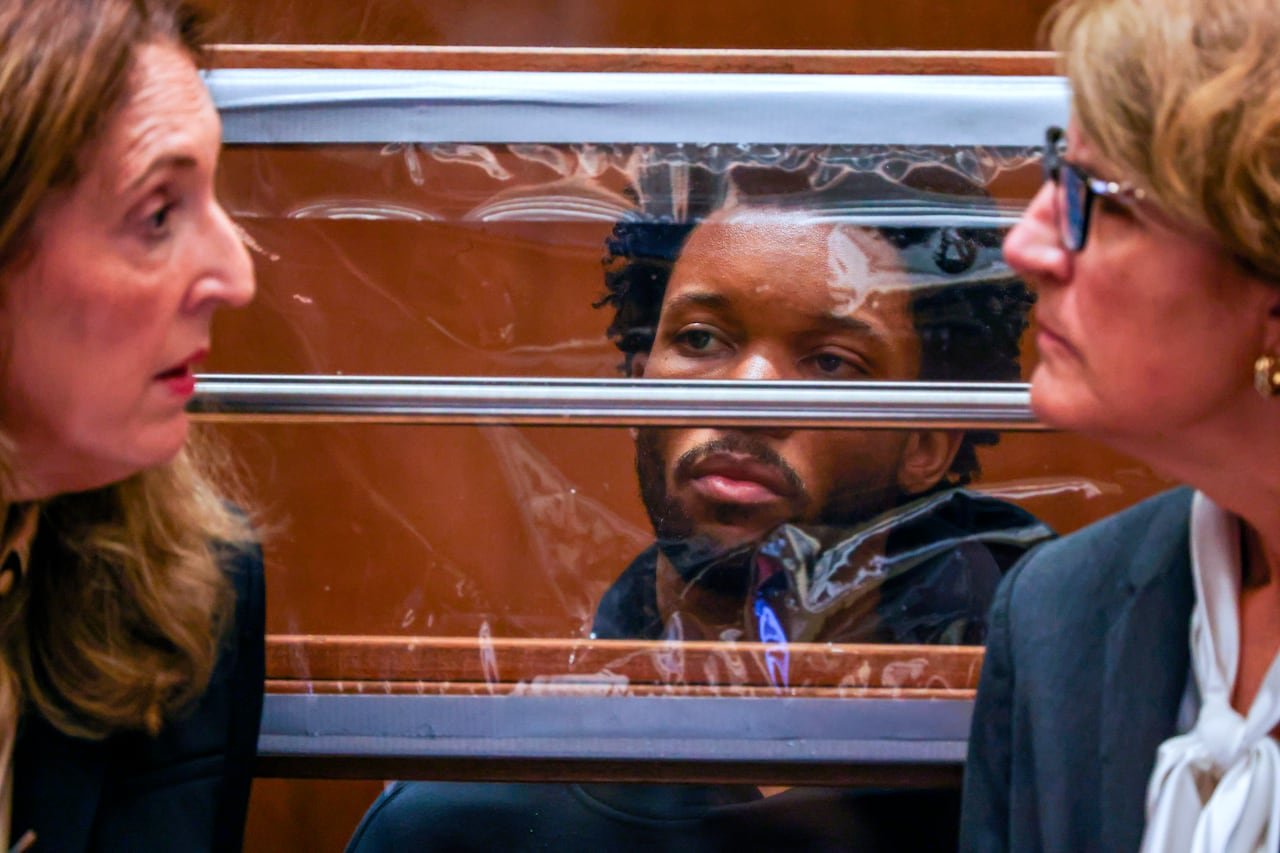 default-415 A man sits behind a plastic screen in a court room