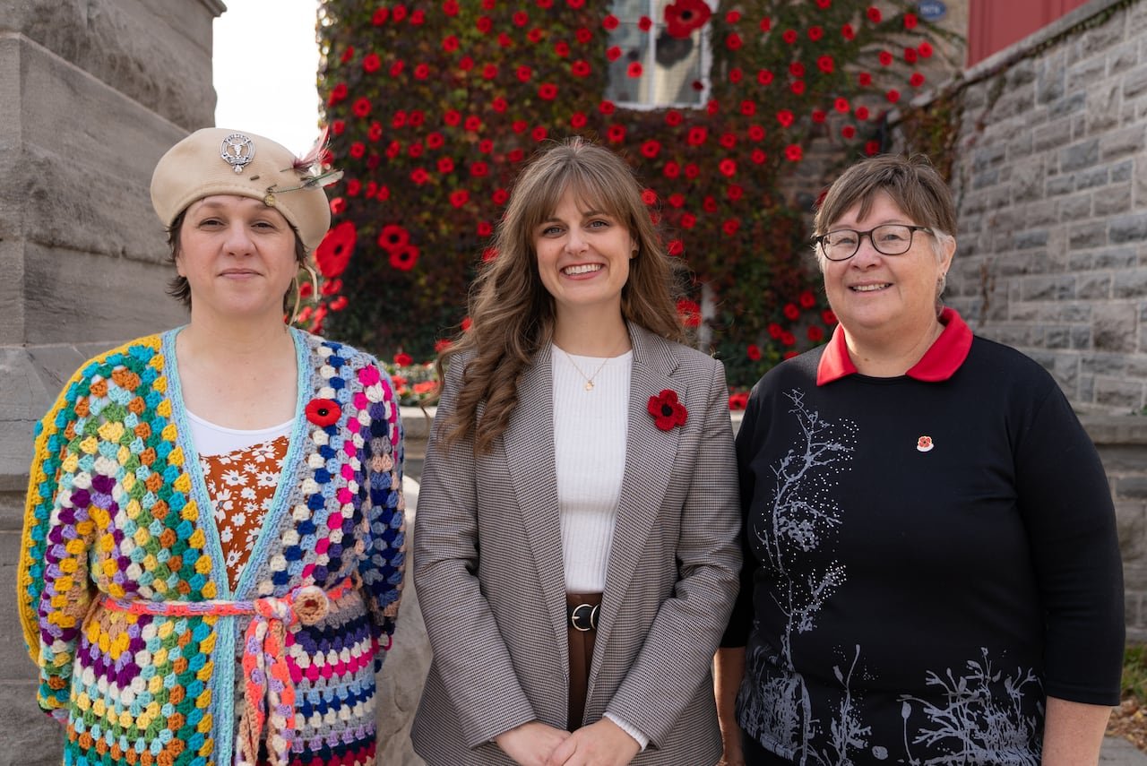 default-15 three women standing side by side in front of museum covered in poppies