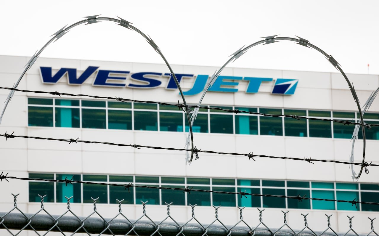 default-246 The WestJet headquarters building is shown beyond razor wire.